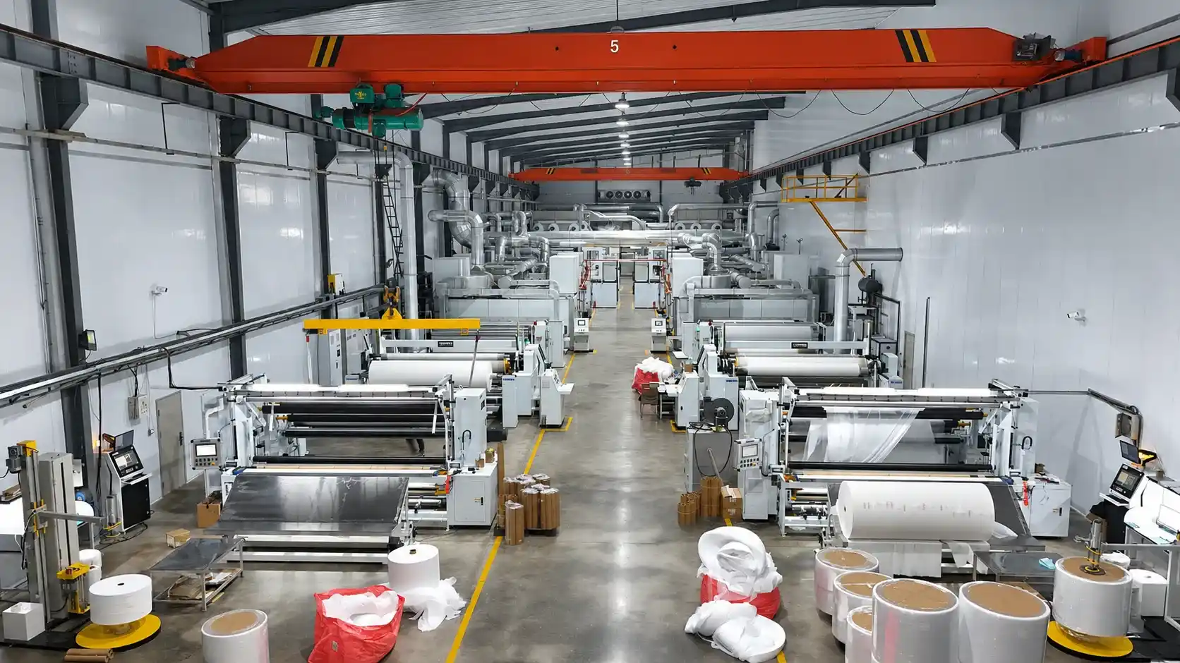 High-capacity automated nonwoven fabric converting and slitting facility for hygiene materials