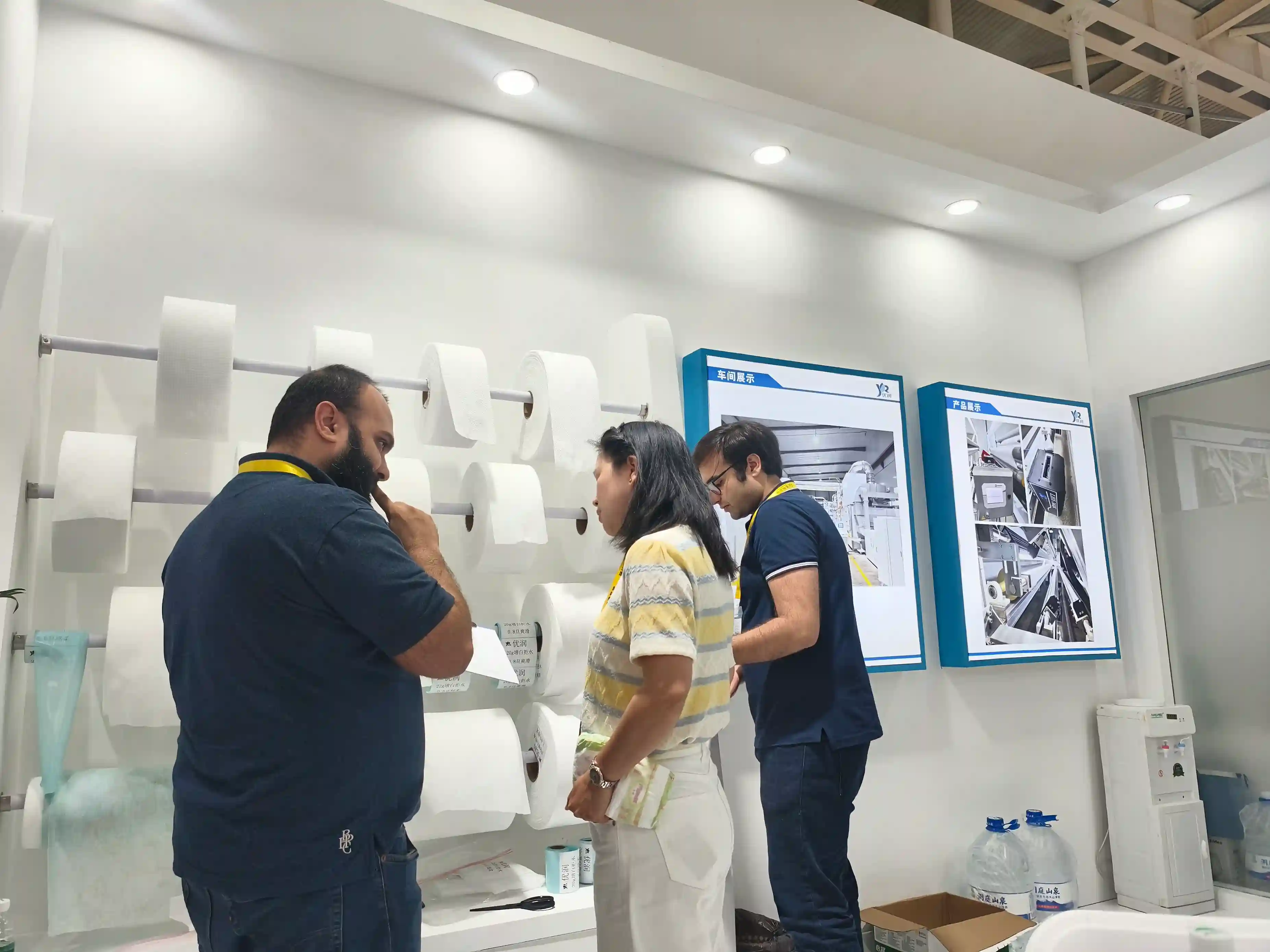  urightmaterials technical team assisting a Middle Eastern procurement manager with on-site inspection of nonwoven fabric samples for absorbent core manufacturing