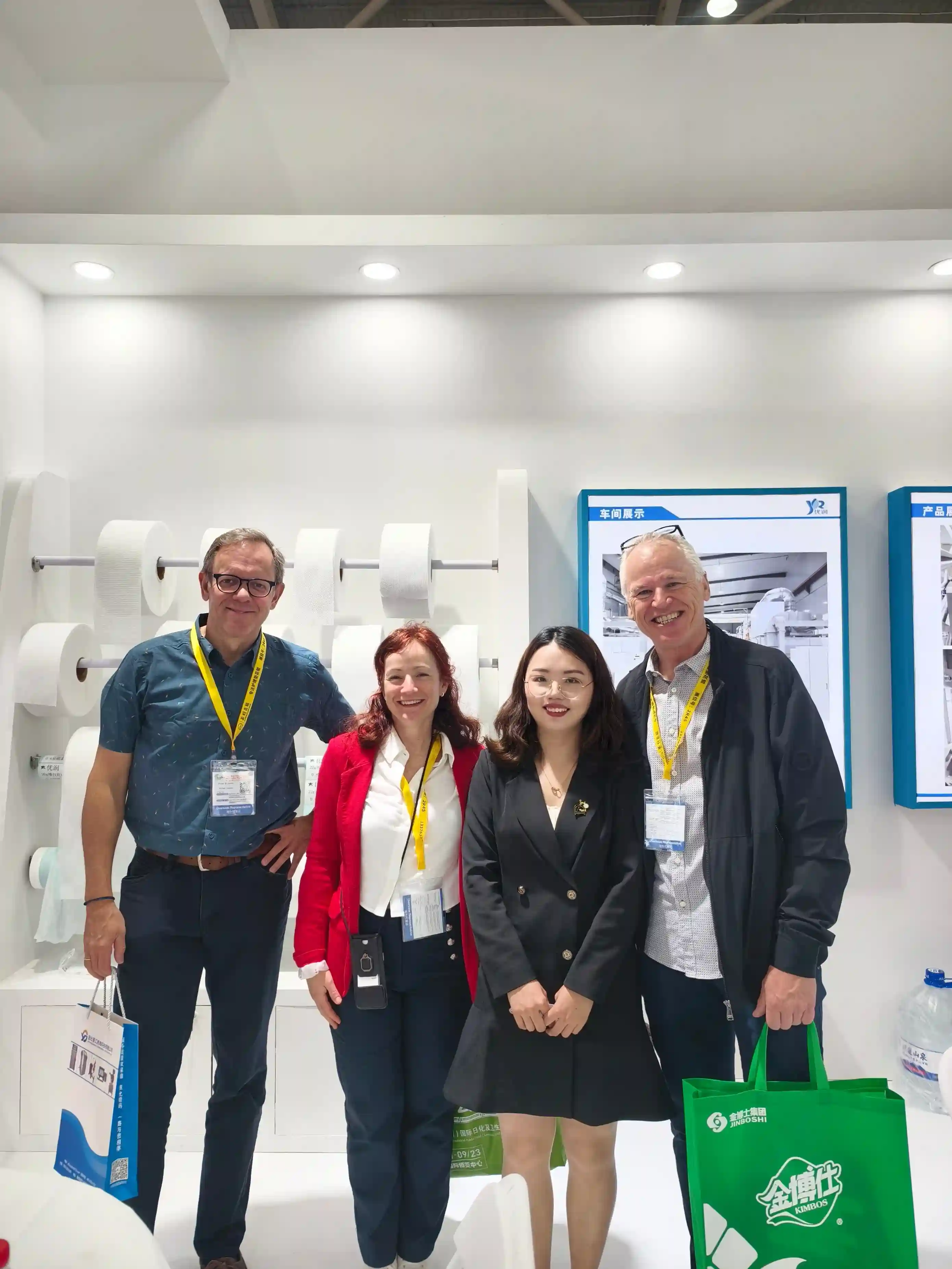 Urightmaterials Representative With Western Hygiene Brand Executives At An International Trade Fair Discussing Premium Nonwoven Fabric Export For Global Supply Chains